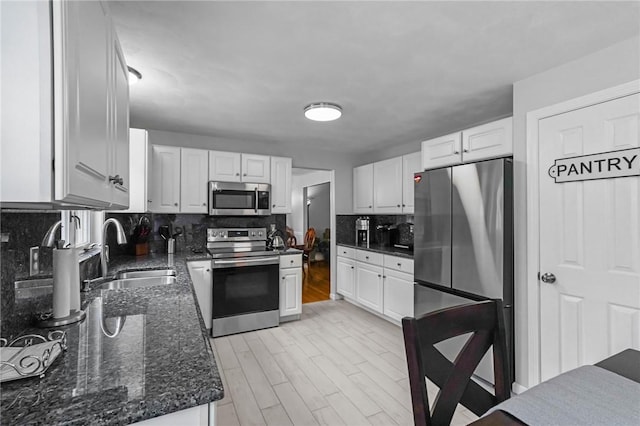 14 Ginger Trl, Coventry, RI 02816 - kitchen featuring stainless steel appliances, a sink, backsplash, white cabinets, and dark stone counters