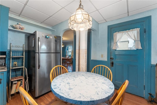 262 Sutton Ave, East Providence, RI 02914 - dining space featuring arched walkways, wood finished floors, a wainscoted wall, and a drop ceiling
