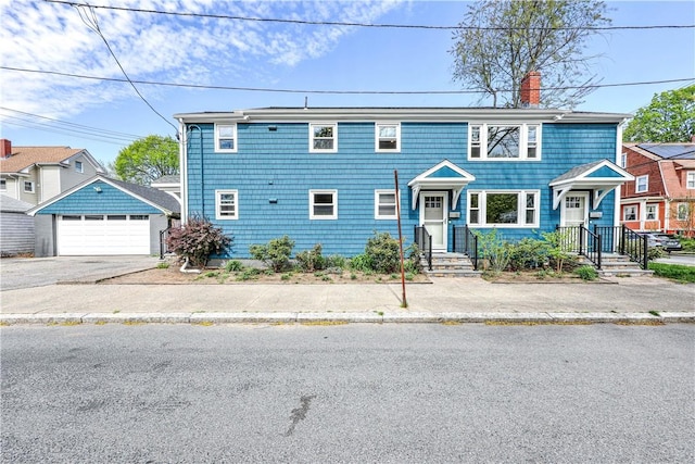 townhome / multi-family property featuring a detached garage, a chimney, and an outdoor structure