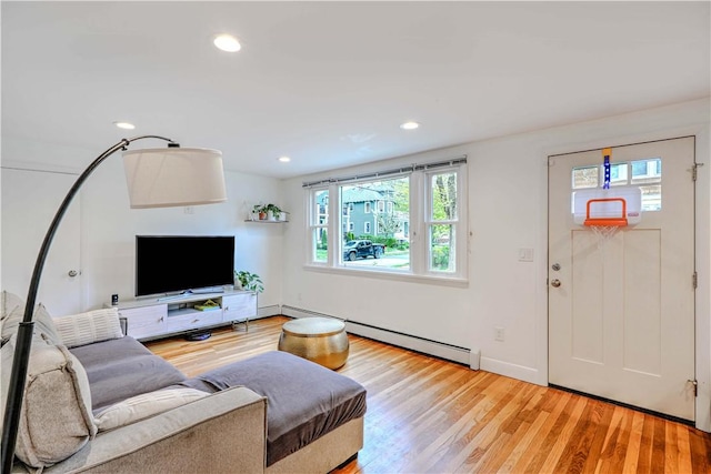 living area featuring a baseboard heating unit, light wood finished floors, and recessed lighting