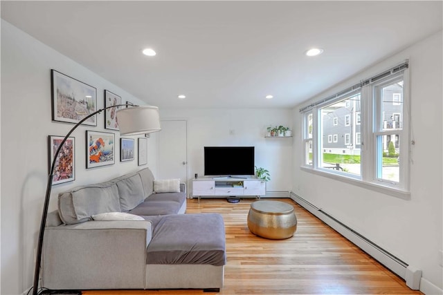 living area with a baseboard heating unit, wood finished floors, recessed lighting, and baseboard heating