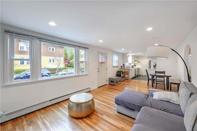 living area with a baseboard heating unit, light wood-style floors, and recessed lighting