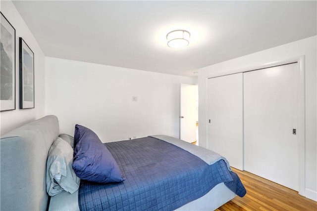 bedroom with light wood-style floors and a closet