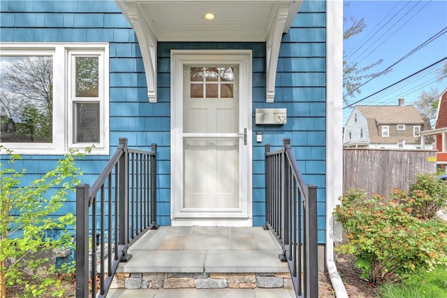 view of exterior entry featuring fence