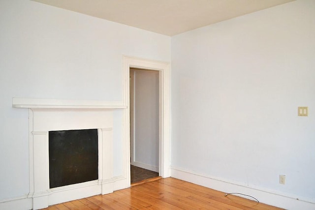 unfurnished living room with light wood finished floors and baseboards