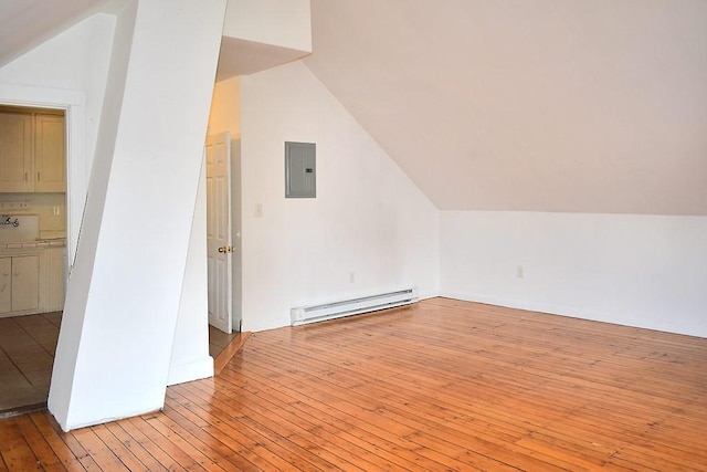 additional living space featuring a baseboard radiator, electric panel, lofted ceiling, and light wood-type flooring