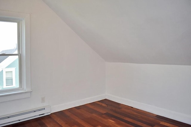 additional living space with baseboard heating, lofted ceiling, dark wood finished floors, and baseboards