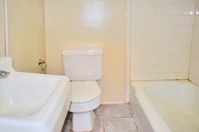 full bath featuring a sink, toilet, a tub to relax in, tile patterned floors, and baseboards