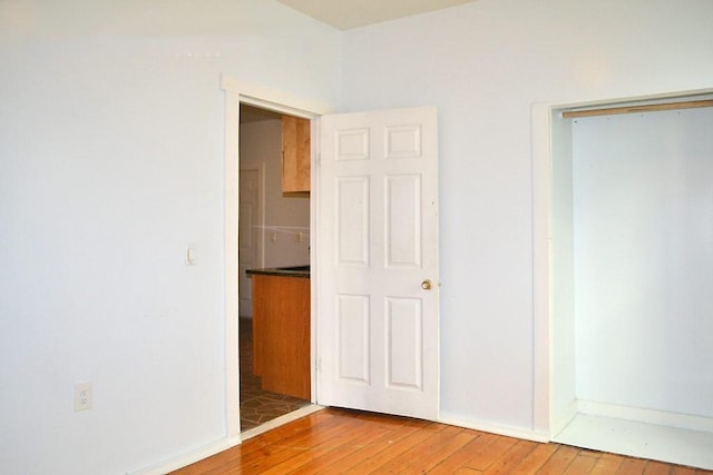 unfurnished bedroom with wood-type flooring and baseboards