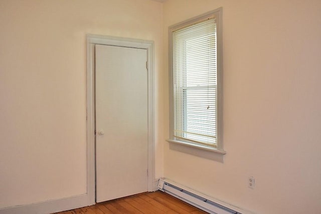 empty room featuring a baseboard radiator and light wood-style floors
