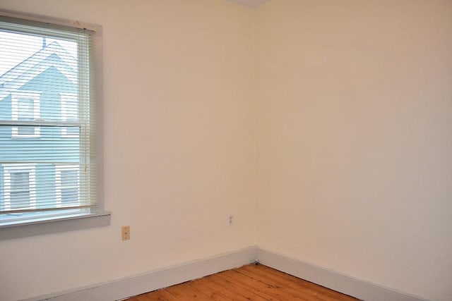 spare room with plenty of natural light, baseboards, and light wood-style floors