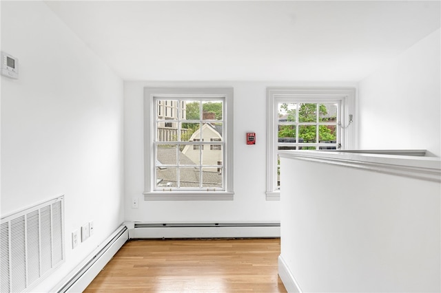 spare room with a baseboard heating unit, a baseboard radiator, and light wood finished floors