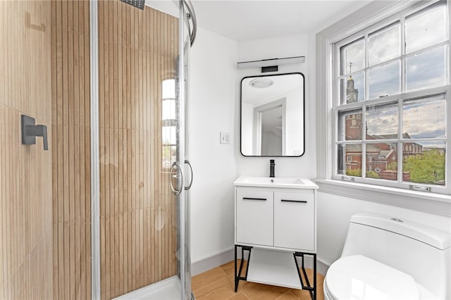 bathroom featuring a stall shower, toilet, and vanity