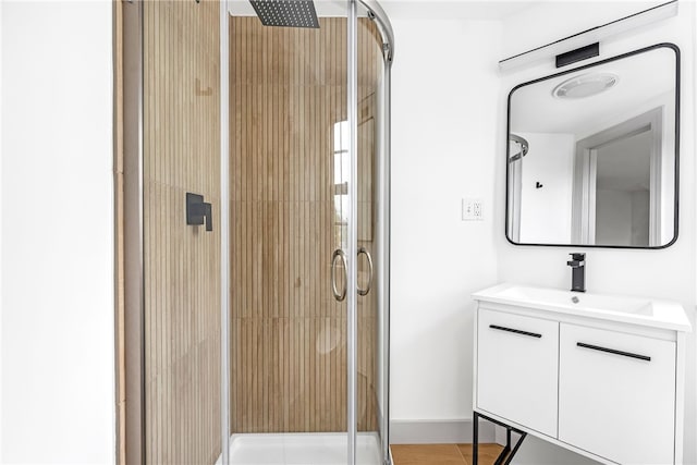 full bathroom with a shower stall, vanity, and baseboards