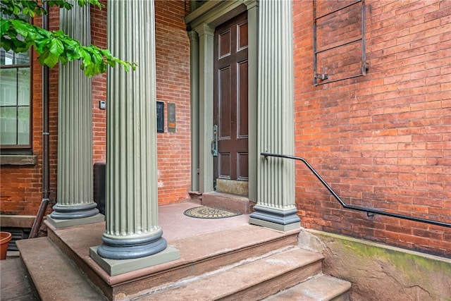 entrance to property featuring brick siding