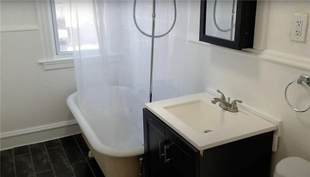 243 Transit St, Woonsocket, RI 02895 - bathroom with vanity, a freestanding bath, baseboards, and toilet