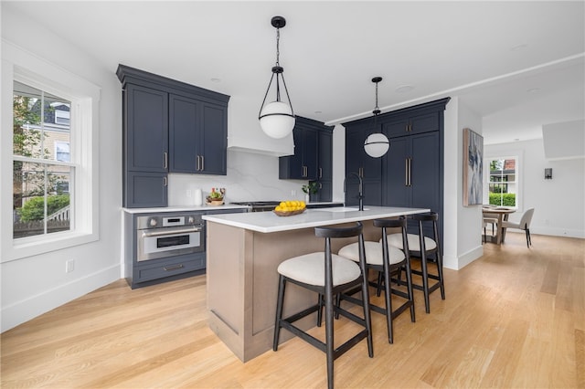 104 Second St, Newport, RI 02840 - kitchen with stainless steel oven, light countertops, a sink, light wood-style flooring, and plenty of natural light