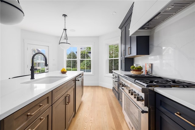 104 Second St, Newport, RI 02840 - kitchen featuring appliances with stainless steel finishes, premium range hood, a sink, light countertops, and light wood-style flooring