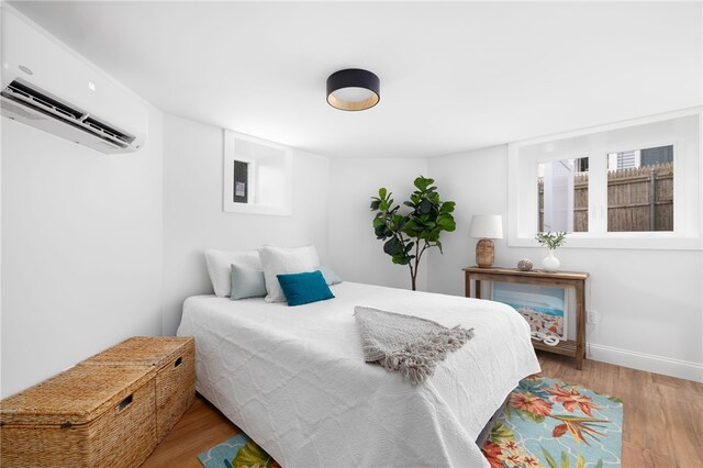 104 Second St, Newport, RI 02840 - bedroom with an AC wall unit, wood finished floors, and baseboards