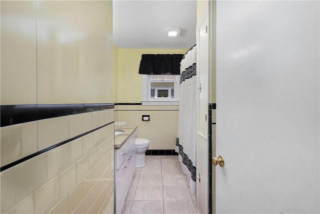 178 Gould Ave, Warwick, RI 02888 - bathroom with tile walls, tile patterned floors, vanity, toilet, and a wainscoted wall