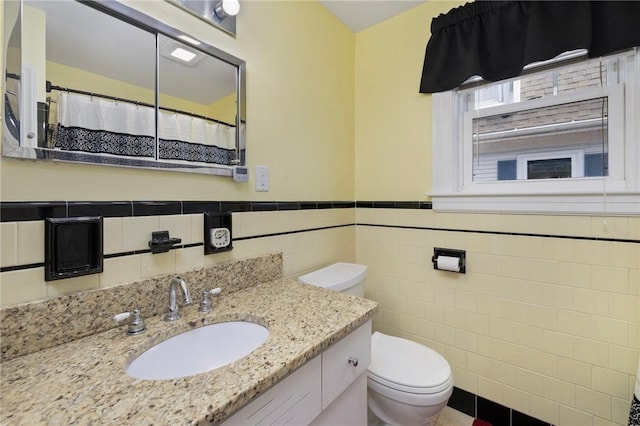 178 Gould Ave, Warwick, RI 02888 - bathroom with tile walls, toilet, wainscoting, and vanity