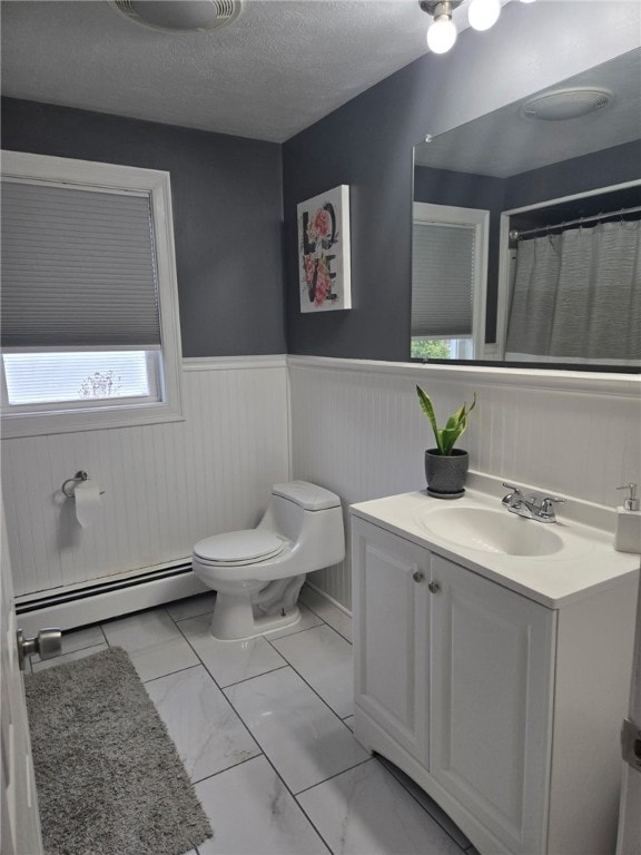 59 Columbus Ave, North Providence, RI 02911 - bathroom with a baseboard radiator, toilet, a wainscoted wall, vanity, and marble look tile flooring