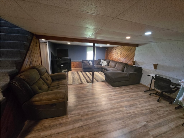59 Columbus Ave, North Providence, RI 02911 - living area with a drop ceiling, wooden walls, wood finished floors, stairs, and a wainscoted wall