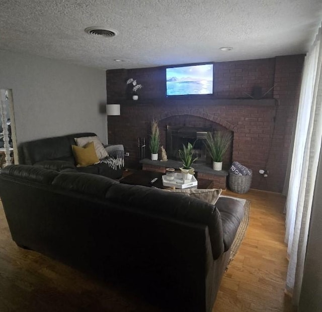 59 Columbus Ave, North Providence, RI 02911 - living area featuring wood finished floors, a brick fireplace, and a textured ceiling