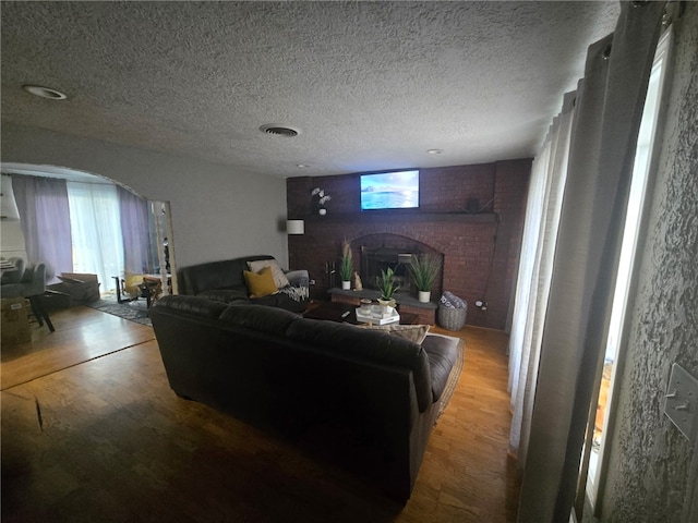59 Columbus Ave, North Providence, RI 02911 - living area featuring a brick fireplace, wood finished floors, and a textured ceiling