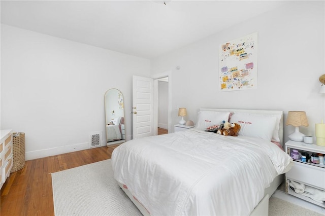 bedroom with wood finished floors and baseboards