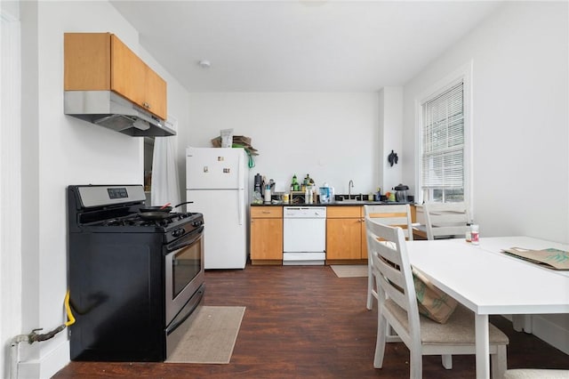 kitchen featuring white appliances, under cabinet range hood, dark wood-style floors, a sink, and dark countertops