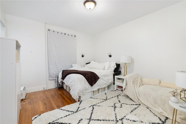 bedroom featuring hardwood / wood-style flooring and baseboards