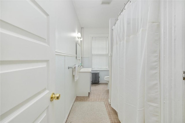bathroom featuring radiator, toilet, tile patterned flooring, and vanity