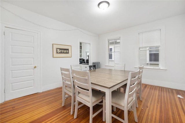 dining area featuring baseboards, light wood-style flooring, and radiator heating unit