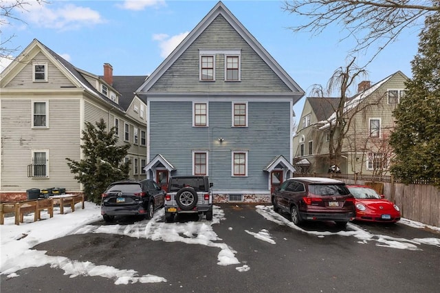 view of front facade with uncovered parking and fence