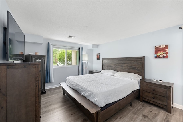 bedroom with wood finished floors and baseboards