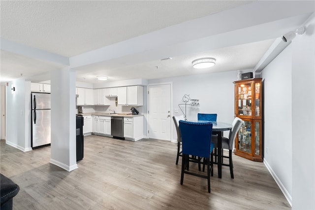 dining area featuring light wood-type flooring and baseboards