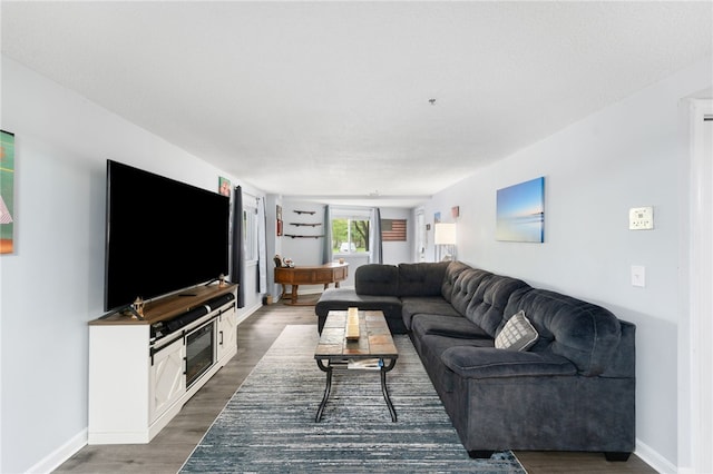living room featuring dark wood-style flooring and baseboards