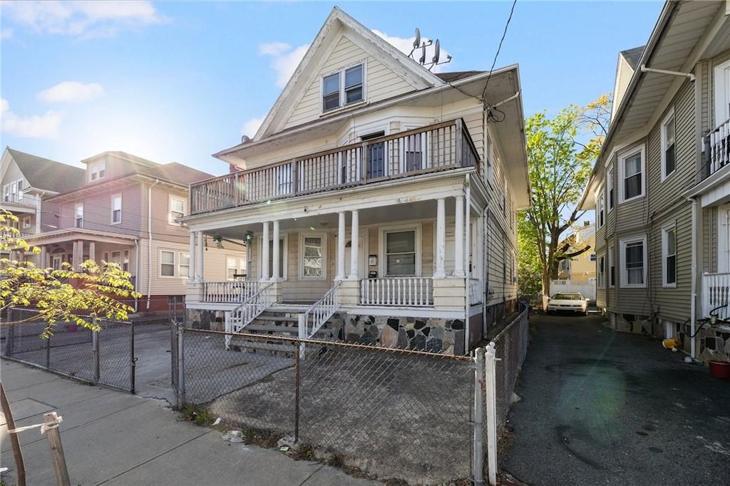 108 Lenox Ave, Providence, RI 02907 - view of front of home with a balcony, a porch, and a fenced front yard