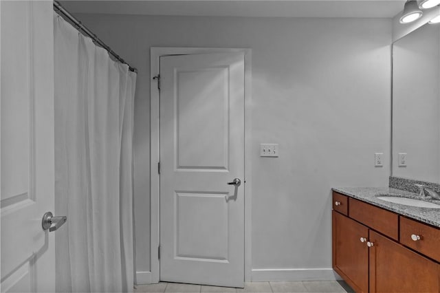 bathroom with vanity, baseboards, and tile patterned floors