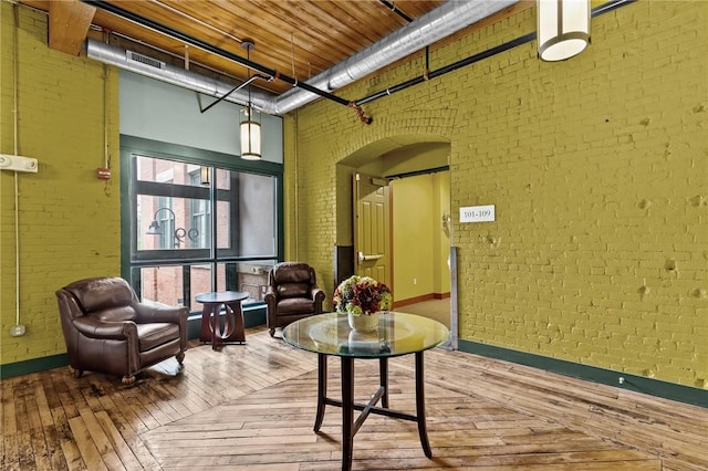 community lobby featuring brick wall and a towering ceiling