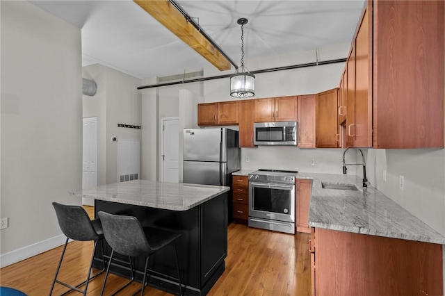 kitchen with stainless steel appliances, a sink, brown cabinets, beamed ceiling, and light wood-type flooring