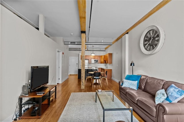 living area featuring baseboards and light wood-style floors