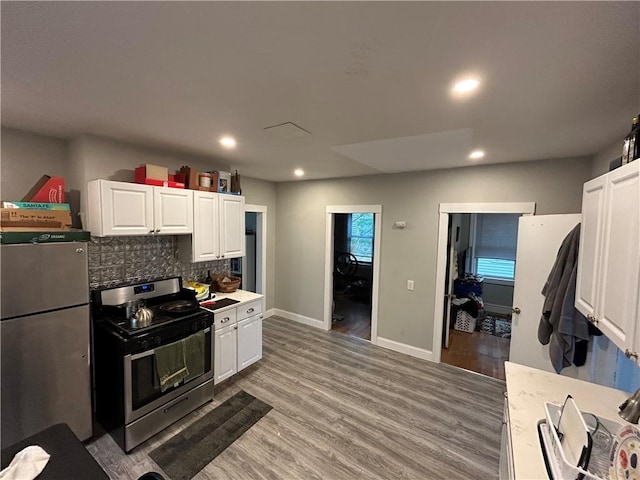 87 Oakland Ave, Providence, RI 02908 - kitchen with stainless steel appliances, white cabinetry, decorative backsplash, light wood finished floors, and recessed lighting