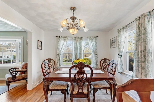 50 Harold St, East Providence, RI 02915 - dining space featuring a chandelier, plenty of natural light, baseboards, and light wood-style flooring