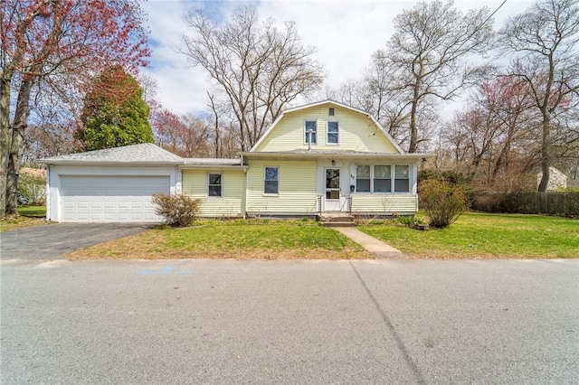 dutch colonial featuring asphalt driveway, a garage, a front lawn, and a gambrel roof