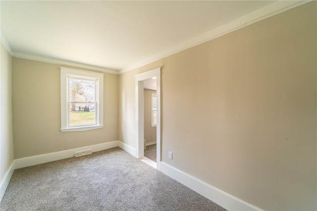 unfurnished room with ornamental molding, carpet flooring, and baseboards