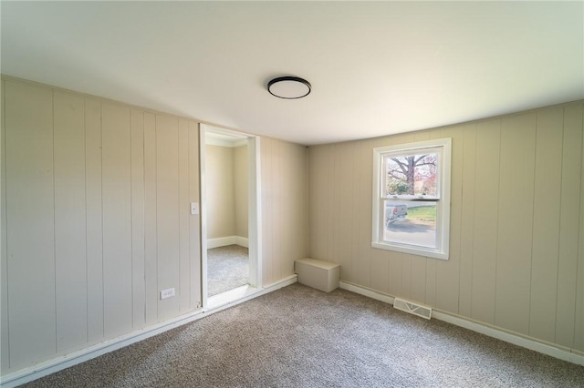 spare room featuring carpet and baseboards