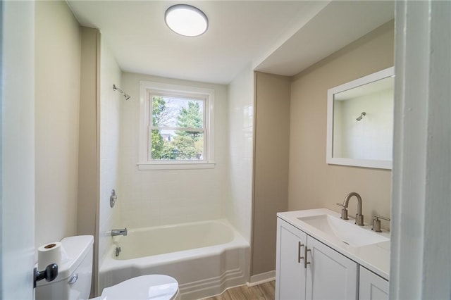 bathroom featuring toilet, shower / tub combination, vanity, and wood finished floors