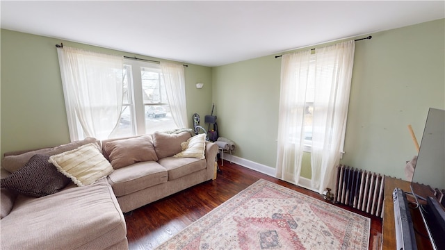 living area featuring radiator, dark wood finished floors, and baseboards